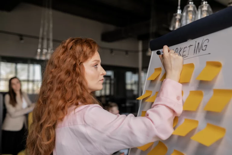 Woman writing on blackboard for strategy meeting