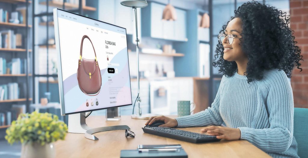 Femme souriante utilisant ordinateur avec sac à l'écran