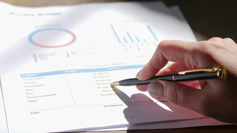 Main analysant des graphiques financiers sur document
