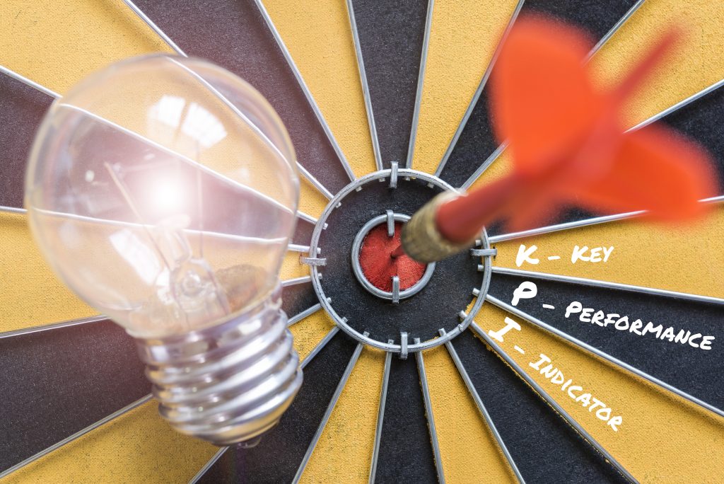 Bulb on dartboard with dart in center, success