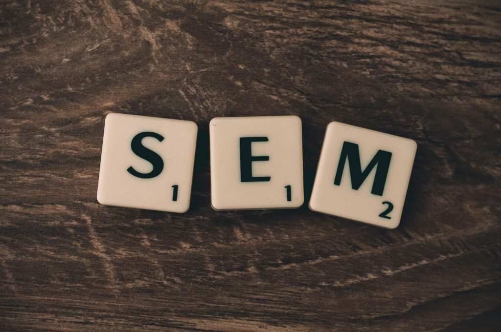 Tiles with letters S E M on wood surface