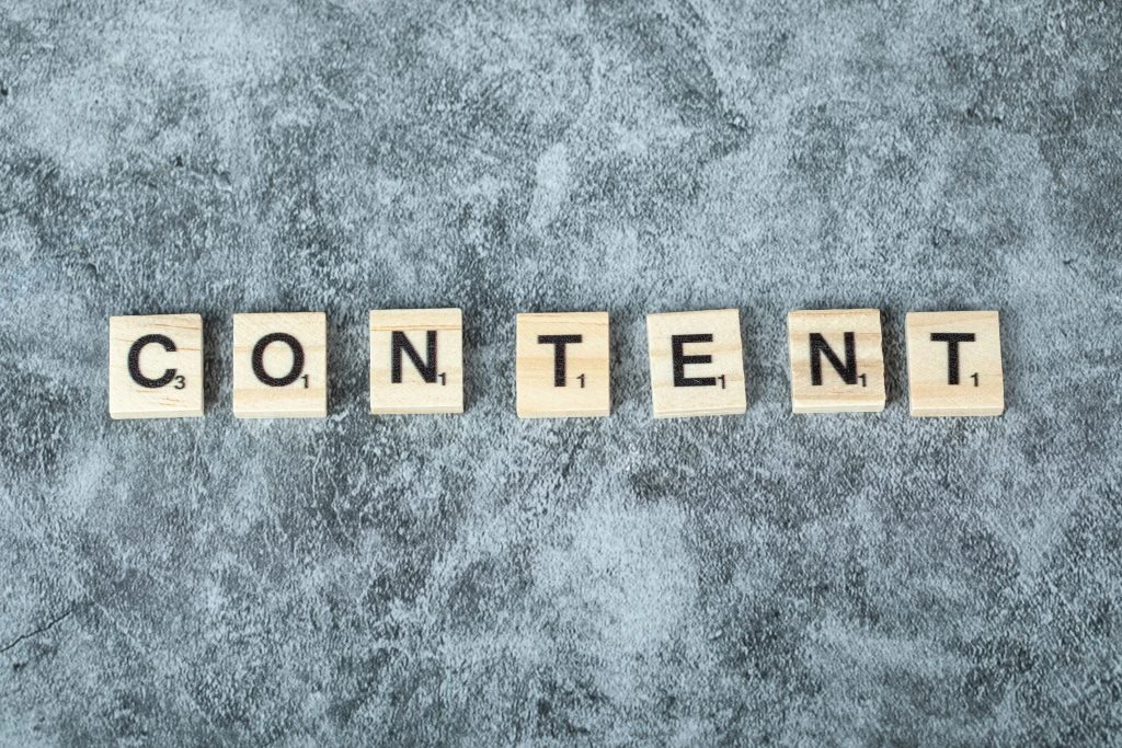 Lettres formant le mot CONTENT sur fond texturé gris