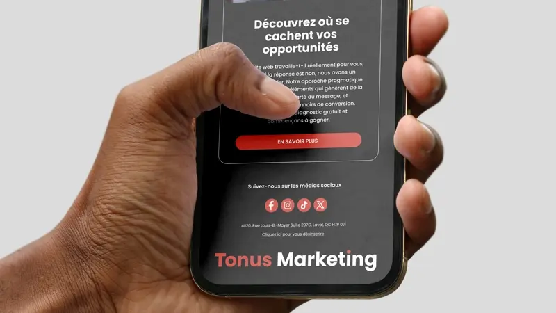Hand holding a smartphone displaying a Tonus Marketing page