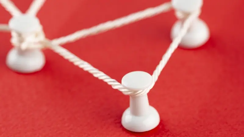 Twine connecting white tacks on a red background