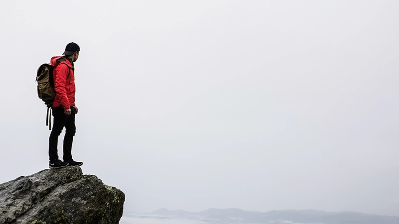 Randonneur sur un sommet rocheux brumeux