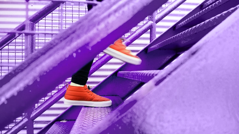 Personne montant des escaliers violets avec souliers orange