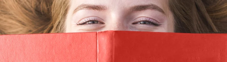 Smiling woman reading a red book