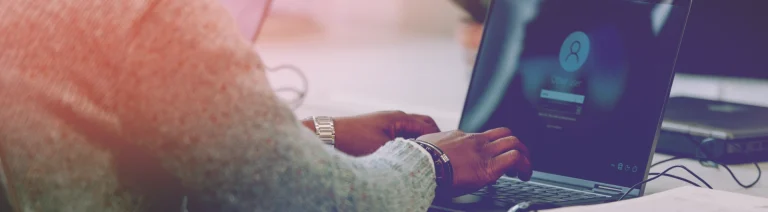 A man sitting in front of his computer, reinforcing the security of his accesses.